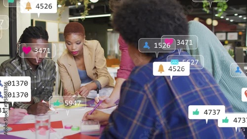 Reacting to social overlays appearing, business team writing sticky notes, sharing markers at table