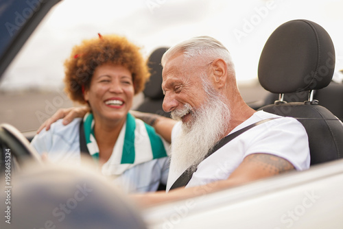 Obraz na plátně Happy senior people having fun during road trip vacation with cabriolet car - In