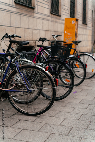 Row of bicycles parked on a city street in an urban European setting. Sustainable transportation and everyday commuting concept highlighting eco friendly lifestyle and modern city mobility.