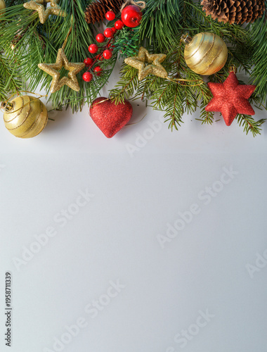 A Christmas composition. Pine and fir branches and fir cones and Christmas balls and decorations on a white background. Flat layout, top view, copy space