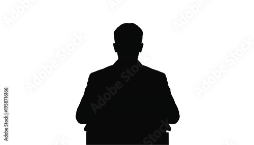 Rear view silhouette of a seated executive wearing a jacket at a podium or desk surface.