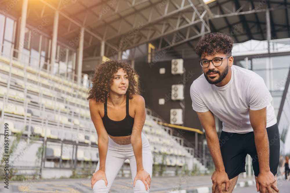 Obraz premium Athletes recovering from jogging, exercising together in an urban sports arena for health and wellness. Healthy lifestyle