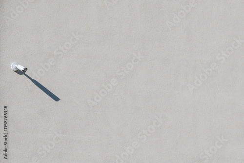Security Camera on White Wall With Long Shadow
