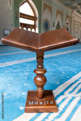 A wooden Rehal (Quran stand) with Masjid engraving on a blue carpet inside a beautiful mosque with ornate architectural detail, Tashkent (Toshkent), Uzbekistan (O'zbekiston)