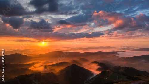 Sunlight illuminating foggy mountain ridges at sunrise
