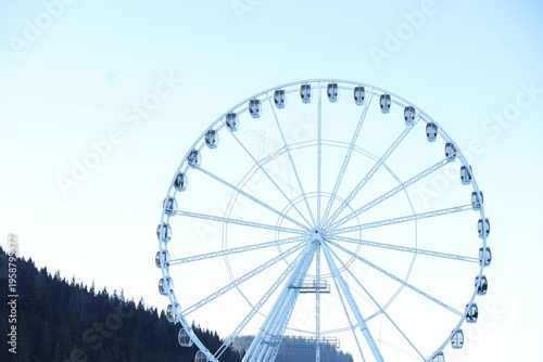 Big Ferris wheel against light blue sky