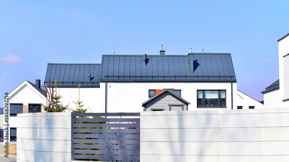Fototapeta premium The real estate market in the suburbs. Terraced family homes in newly developed housing estate. New single family houses in a new development area. Residential homes with modern facade. 
