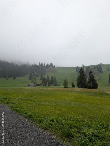 Tableau sur toile Quiet cabins in the Swiss Alps beneath fog-shrouded hills