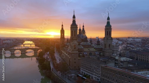 Aerial View Capturing Sunset Glow Illuminating Cathedral Domes And Tranquil River Reflections. Zaragoza. Spain 