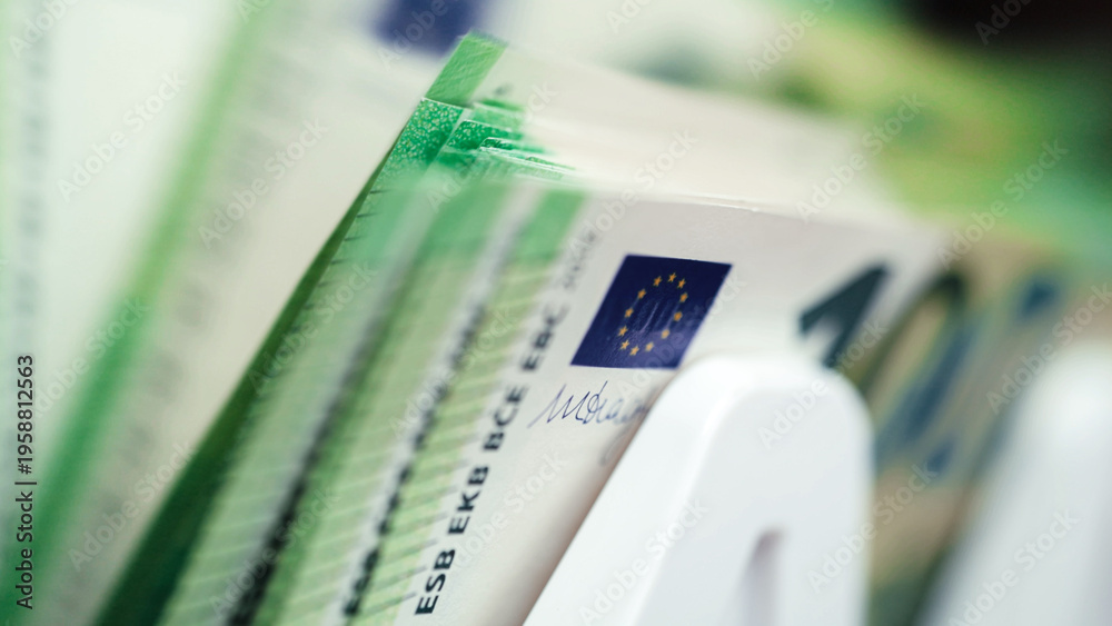 Fototapeta premium Money counting machine processing stacks of cash with visible Euro banknotes, showcasing detailed currency features and a clean, organized workspace environment