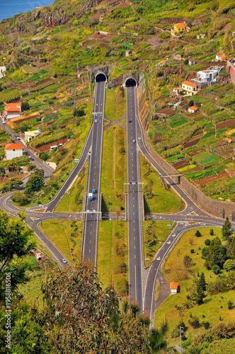 A scenic bridge over a river with traffic on a highway surrounded by nature and mountains in Madeira