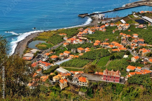 Panoramic view of a coastal town in Madeira with a sea bay, mountains, and a summer Mediterranean landscape