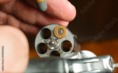 Hands of an experienced man handling a classic revolver