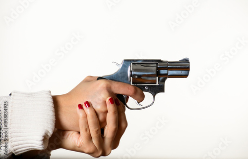 Confident Young Woman Displaying a Handgun in Minimalist Setting