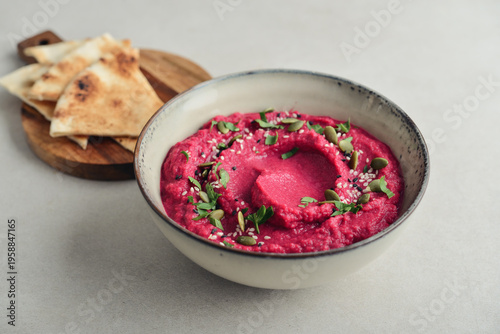 Beetroot hummus decorated with sesame and pumpkin seeds