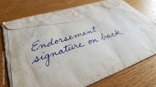 Handwritten instructions for an endorsement signature on the back of a brown envelope.