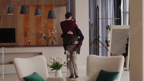 Couple embraces in modern living room during heartfelt reunion