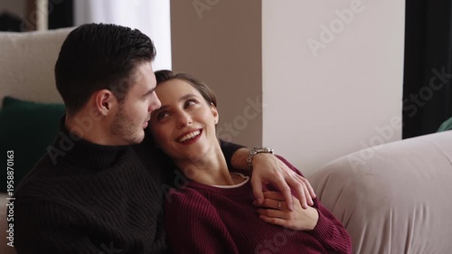 Cozy couple shares a tender moment on the couch in a warm setting
