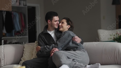 Couple enjoys intimate moment on a cozy couch in a modern living room
