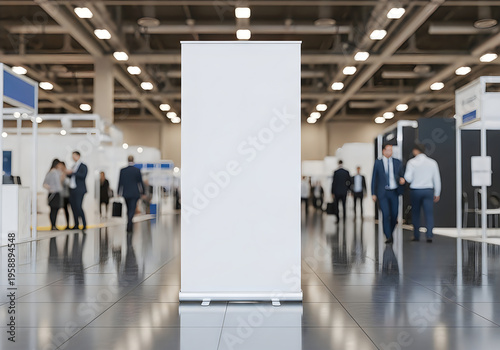 A large white sign in a convention center with people walking around
