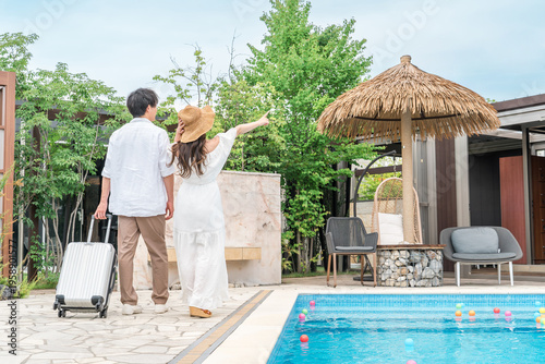 Cuadro en lienzo A young Asian couple walking by the poolside of a resort hotel (traveling, honey