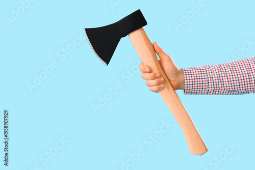 Hand with ax on blue backgr...