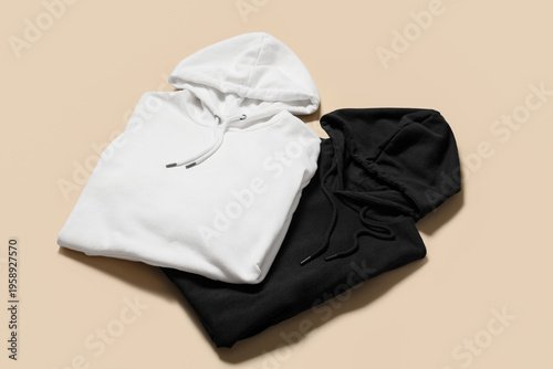 Stylish hoodies on beige ba...