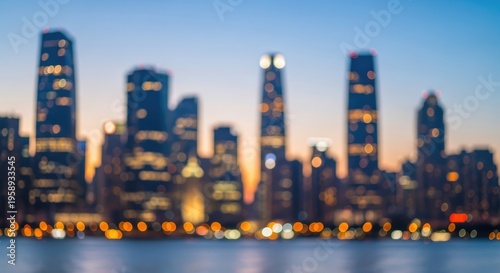 Blurred Cityscape at Dusk with Illuminated Skyscrapers and Waterfront Reflection.