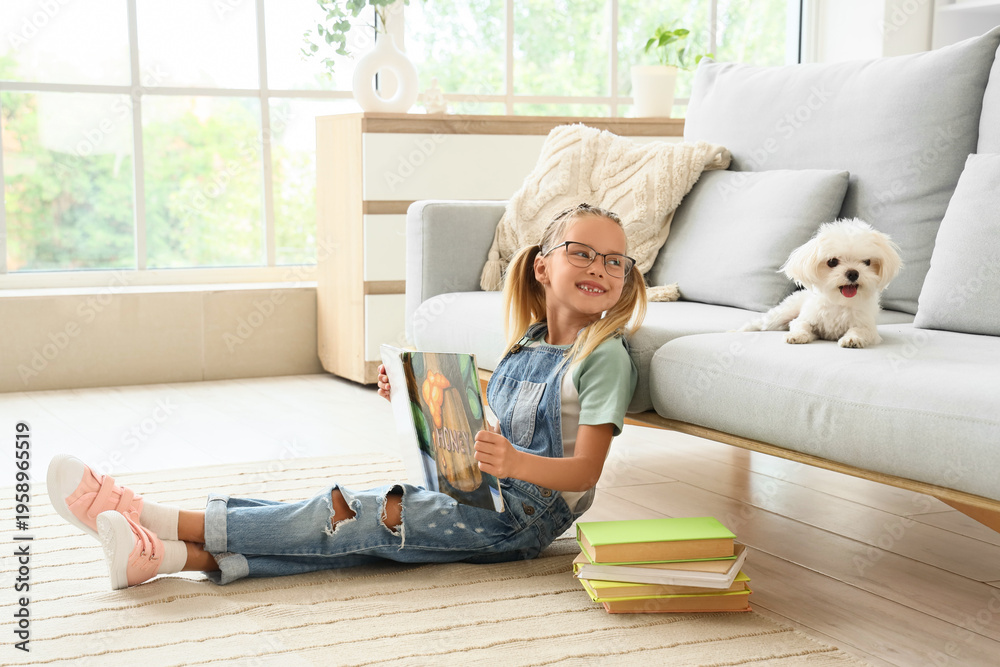 Obraz premium Cute little happy girl with Maltese dog and books reading on floor at home