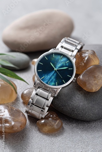 an elegant stainless steel watch with blue color in it, resting on brown amber stones