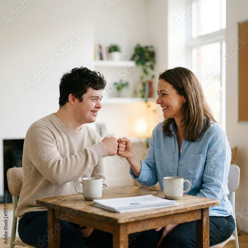 A man with Down syndrome and a woman sit at a table drinking coffee and talking, inclusive friendship, cozy cafe moment, supportive social interaction.