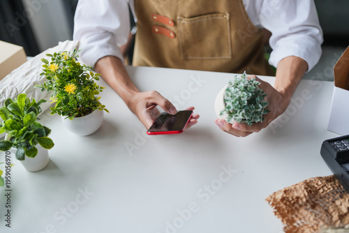 Asian Male Small Business Owner of Eco-Friendly Plant Shop Carefully Managing Daily Sales Income and Expenses