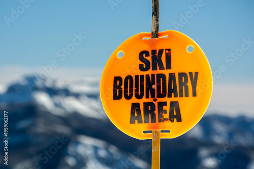 Orange Ski Boundary Area Warning Sign on a Sunny Winter Day