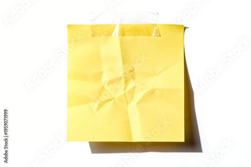 Yellow crumpled sticky note on white background