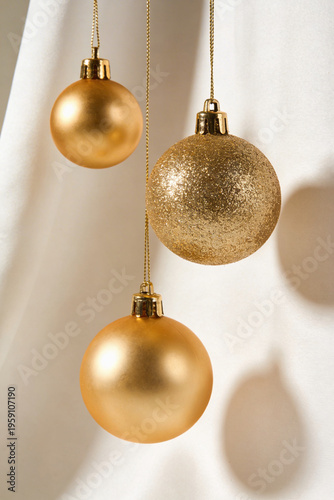 Three Gold Christmas Bauble Ornaments with Different Textures Hanging on Soft Background Illustration