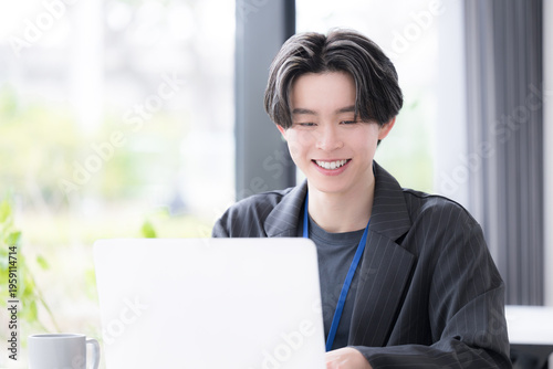 パソコンでタイピングで仕事する若いビジネスマン　若手社員の爽やかな成長と成功のビジネスシーン