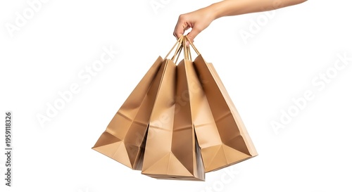 A close up view of a woman's hand holding several brown paper shopping bags against white background