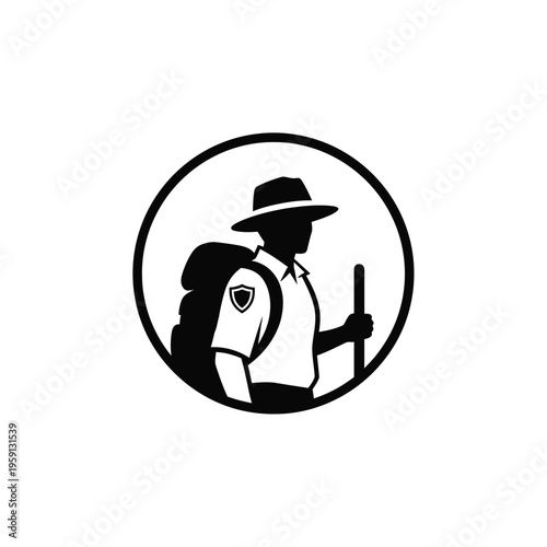 Silhouette of person wearing hat backpack and holding stick