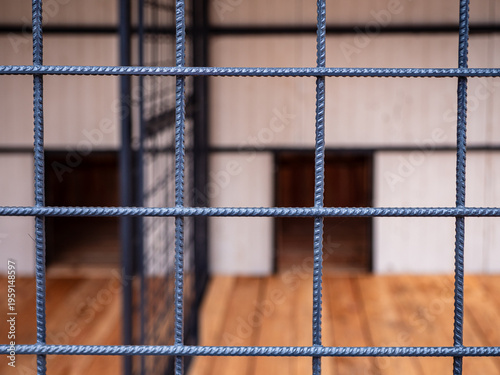 Obraz na płótnie Close-up of steel wire mesh in dog kennel with blurred interior showing partition and wooden dog houses, highlighting durable construction and enclosure design