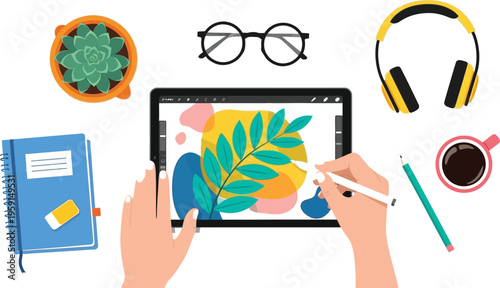Hands drawing colorful abstract design on a digital tablet surrounded by creative workspace accessories like headphones and coffee.
