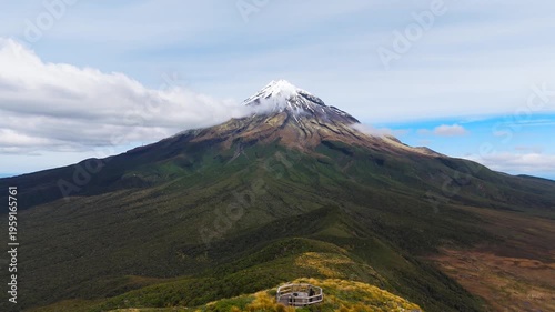 Wallpaper Mural Majestic Mount Taranaki in New Zealand, the snow-capped volcanic peak, forested slopes and a scenic viewpoint beneath drifting cloud, cinematic aerial dolly view Torontodigital.ca