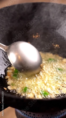 Cooking ingredients sizzling in a hot pan with oil and steam