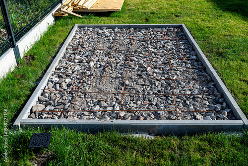Foundation base for garden outbuilding construction in yard