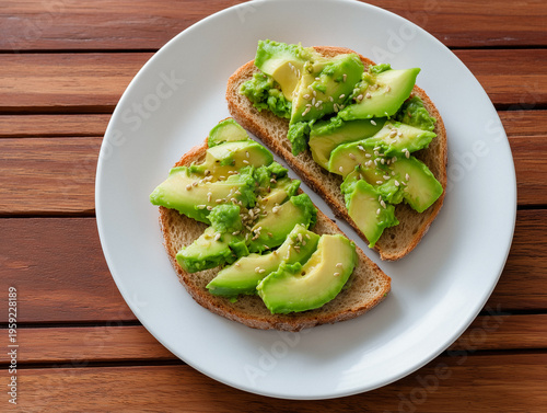 Simple toast topped with avocado slices and sesame seeds on a white plate against a wooden background