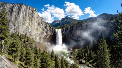 Majestic waterfall cascades down a sheer rock face into a flowing river