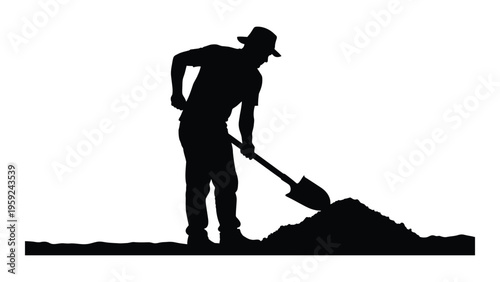 A silhouette of a man digging with a shovel in a pile of dirt