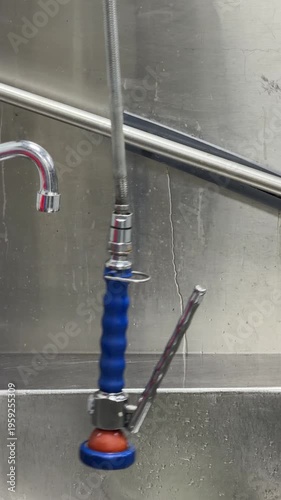 Commercial kitchen sink sprayer swinging like a pendulum