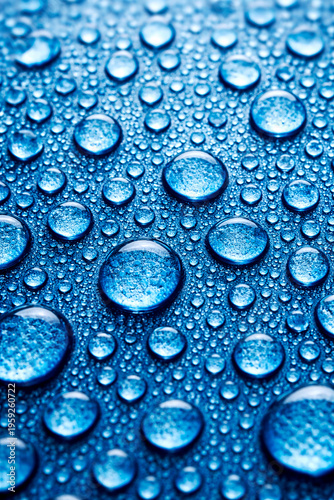 Macro close up of blue water droplets densely covering a textured background under even lighting