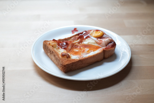 Breakfast menu, egg with cheese on toast and tomato sauce with light and shadow from window in the morning.