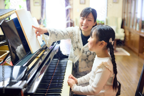 ピアノ教室でレッスンを行う先生と生徒の女の子